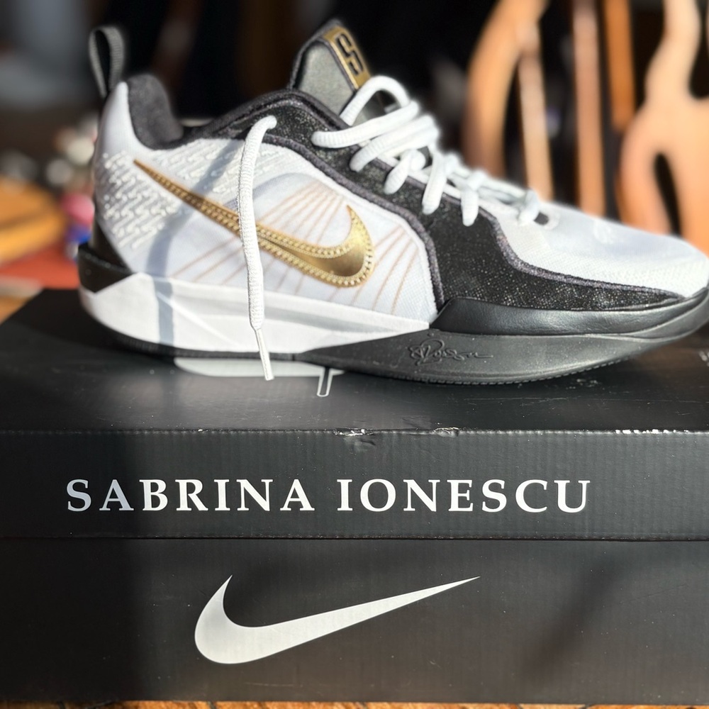 Nike Kids White and Black Sneakers with Gold Swoosh